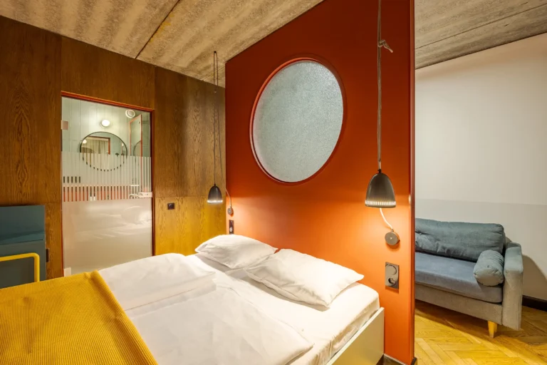 Stylowy i kolorowy pokój hotelowy z podwójnym łóżkiem i sofą.