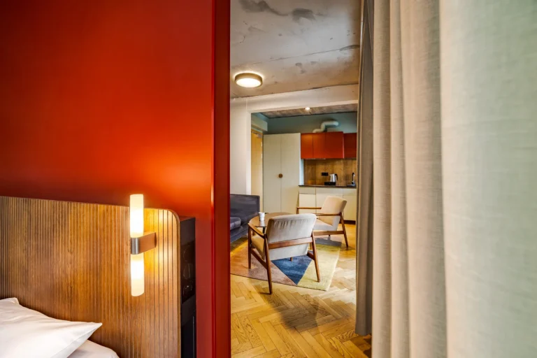 Pokój hotelowy z czerwoną ścianą w starej modernistycznej willi.