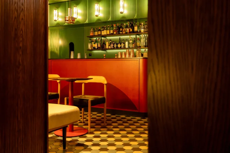 Klimatyczny hotelowy bar z nastrojowym oświetleniem i wystrojem nawiązującym do art déco.