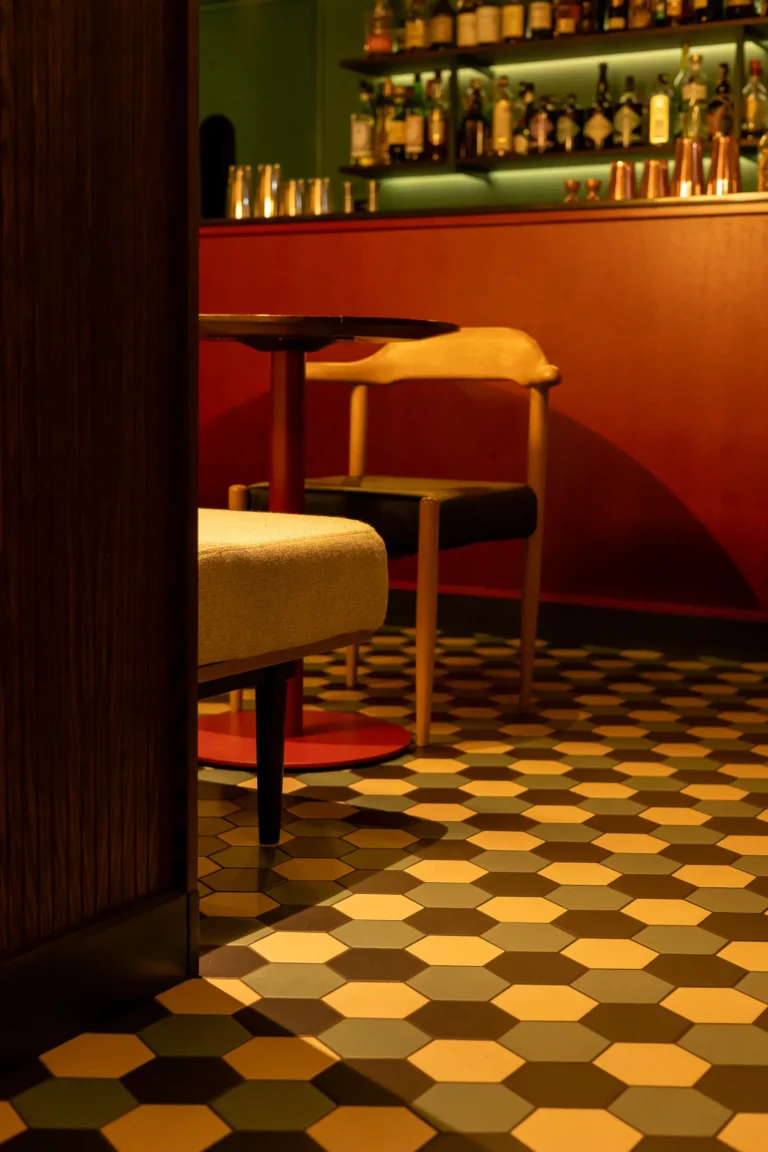 Hotelowy bar z klimatycznym oświetleniem i czerwonym barem.