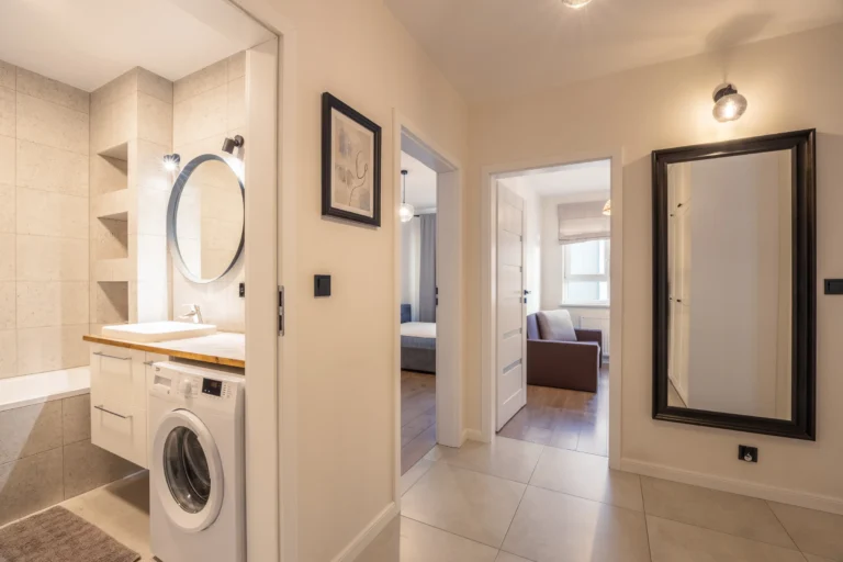 Jasny korytarz, łazienka i pokoje niewielkiego mieszkania w Warszawie.