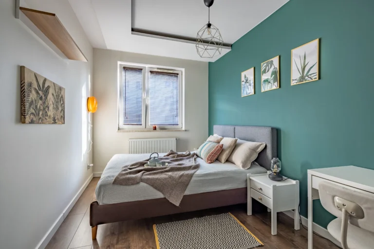 Przytulna sypialnia z dużym łóżkiem i wzorzystym dywanem.