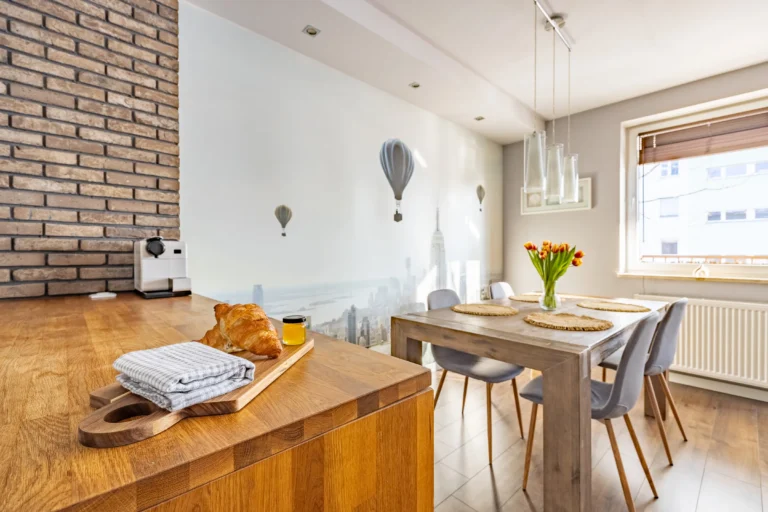 Jasna jadalnia z dużym drewnianym stołem.